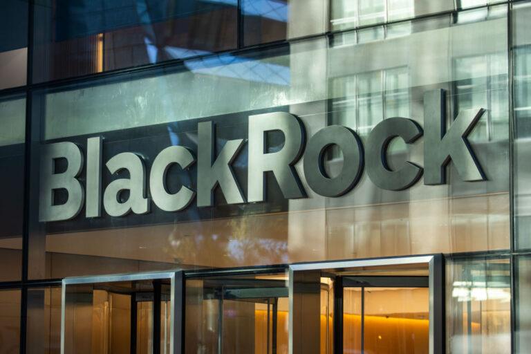 Zdjęcie przedstawiające logo firmy BlackRock nad wejściem do biurowca.