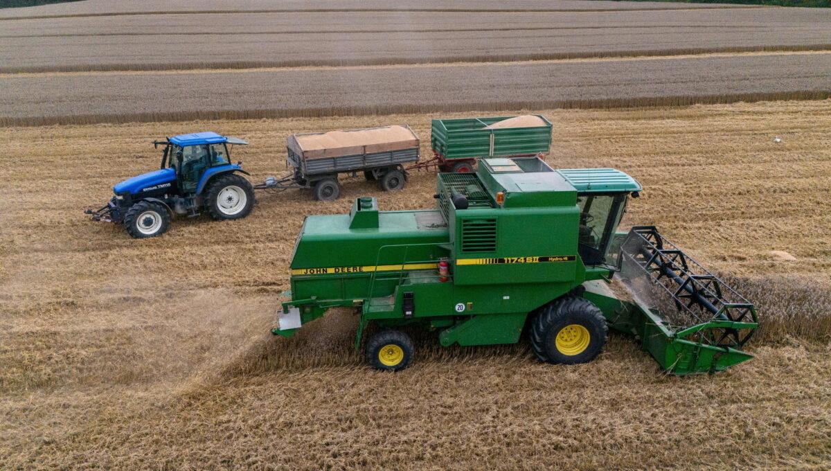 Na zdjęciu widać kombajn i traktor na polu.