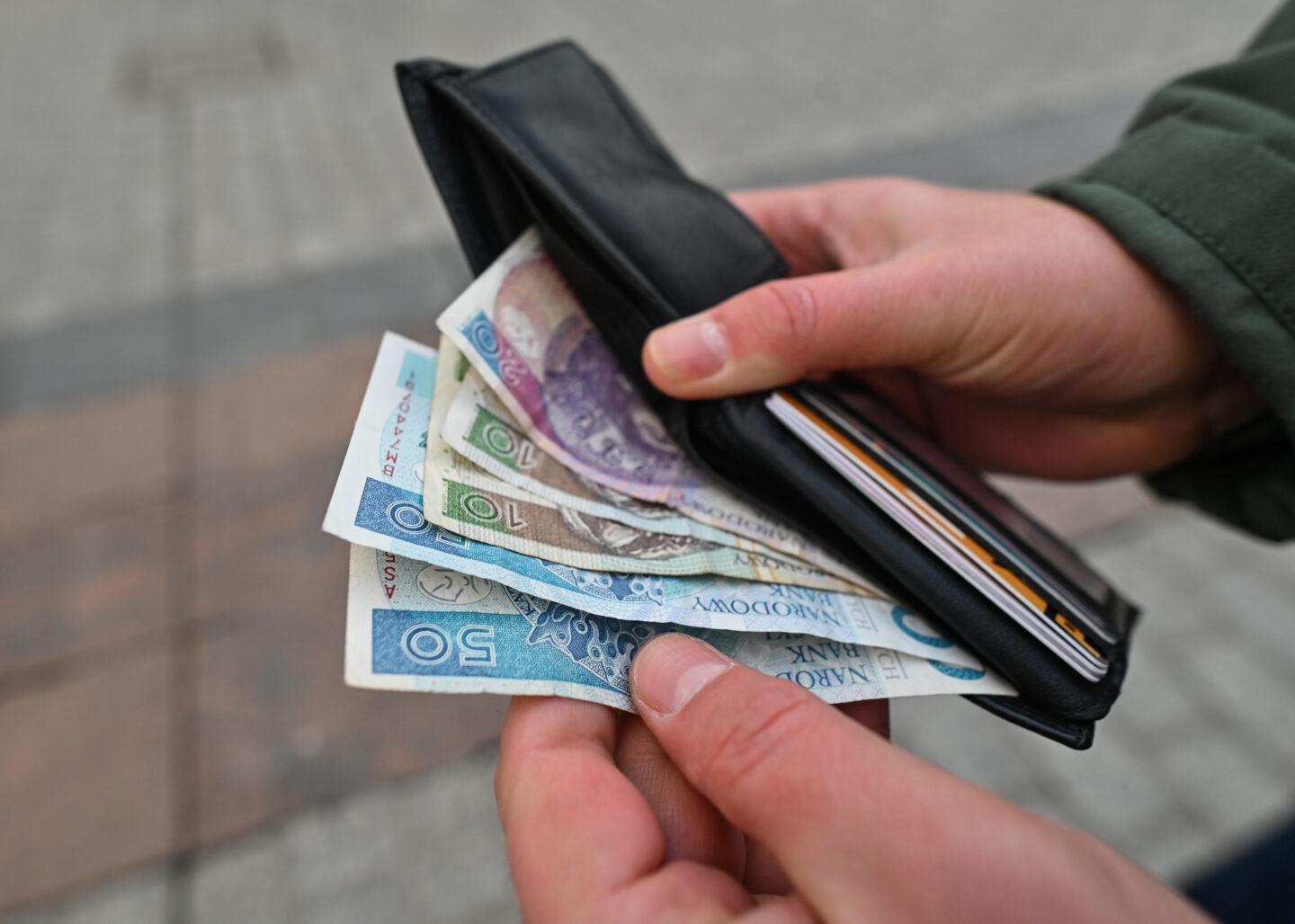 Zdjęcie przedstawia banknoty 50-, 20- i 10-złotowe w portfelu