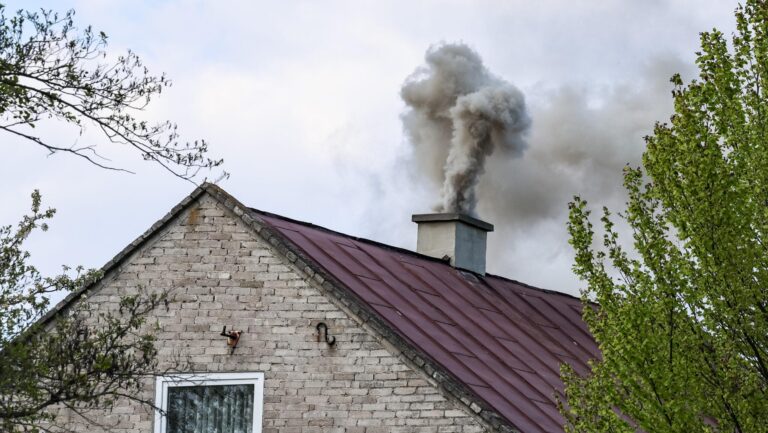 Na zdjęciu dom. Z komina leci dym.