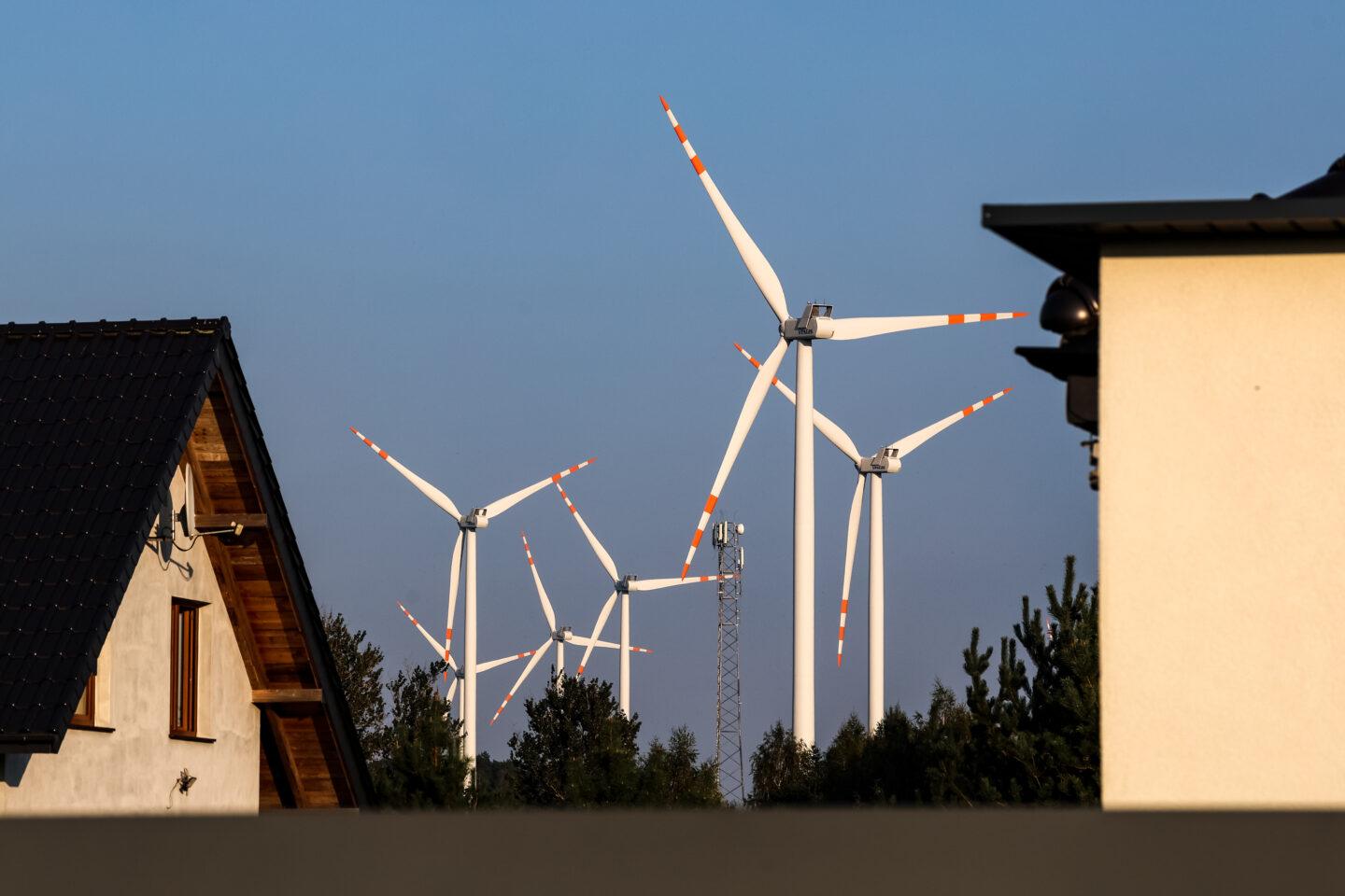 Wiatraki produkujące energię nad dachami domów