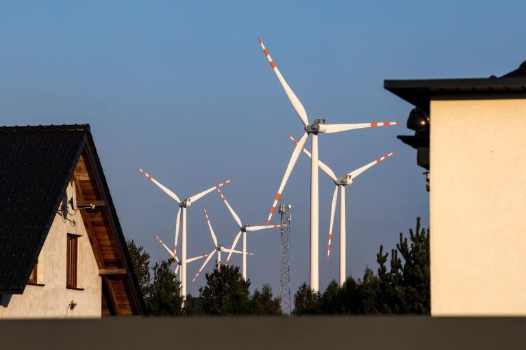 Wiatraki produkujące energię nad dachami domów