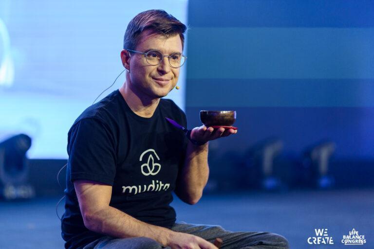 Na zdjęciu Michał Kiciński w koszulce z nadrukiem Mudita, nazwą jego spółki technologicznej, podczas wystąpienia na konferencji.