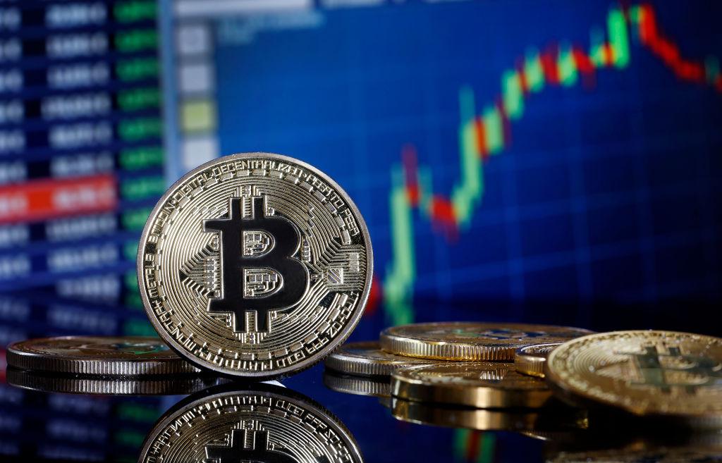 Zdjęcie przedstawia logo bitcoina na tle wykresu