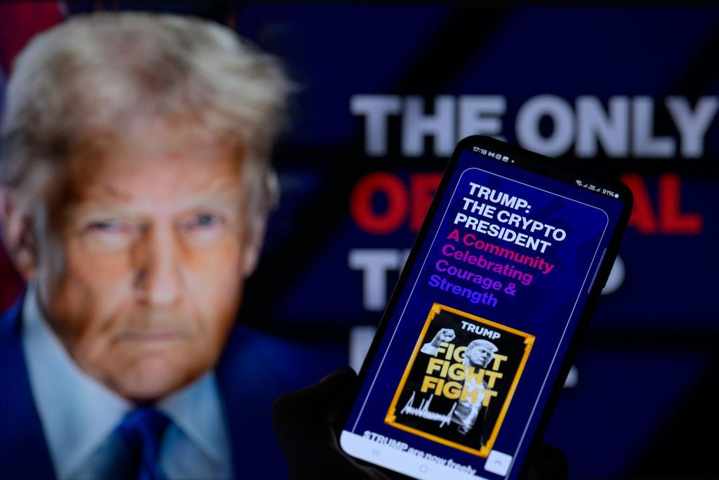 Na zdjęciu Trump i logo jego waluty
