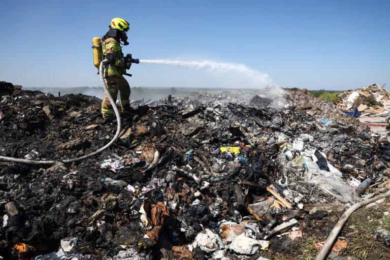 Na zdjęciu strażak gasi pożar na wysypisku