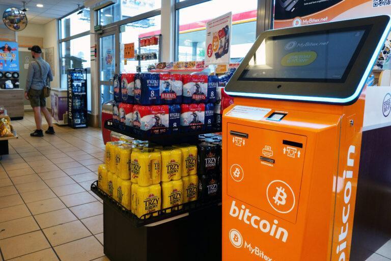Na zdjęciu puszki piwa obok automatu do zakupu bitcoinów na stacji benzynowej
