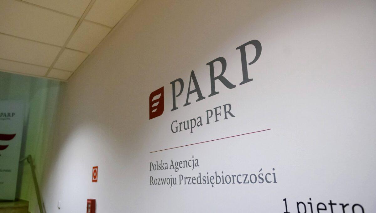 Na zdjęciu logo PARP na klatce schodowej