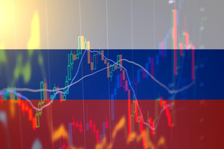 Na grafice flaga Rosji na tle wykresów giełdowych