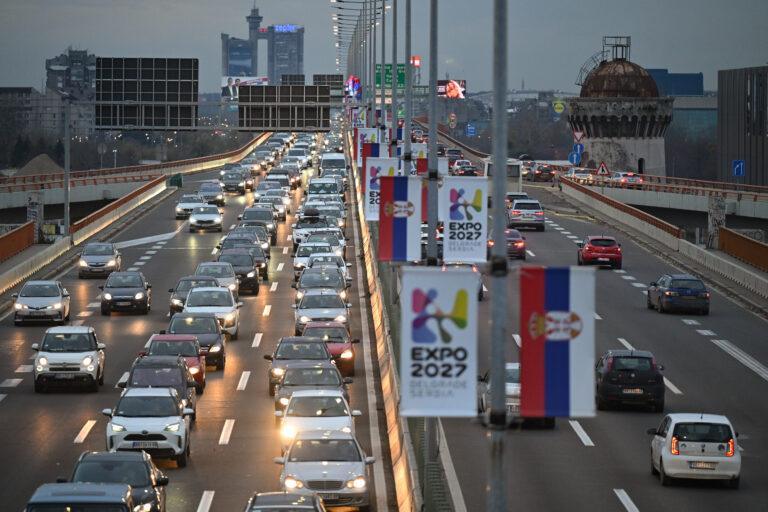 Zatłoczona obwodnica w Belgradzie, stolicy Serbii, z flagami Expo 2027 oraz flagami narodowymi