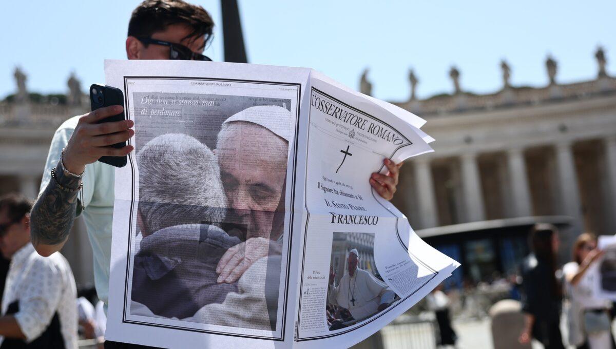 Osoba przegląda wydanie „L’Osservatore Romano” dzień po śmierci papieża Franciszka, na placu Świętego Piotra w Watykanie, 22 kwietnia 2025 r.