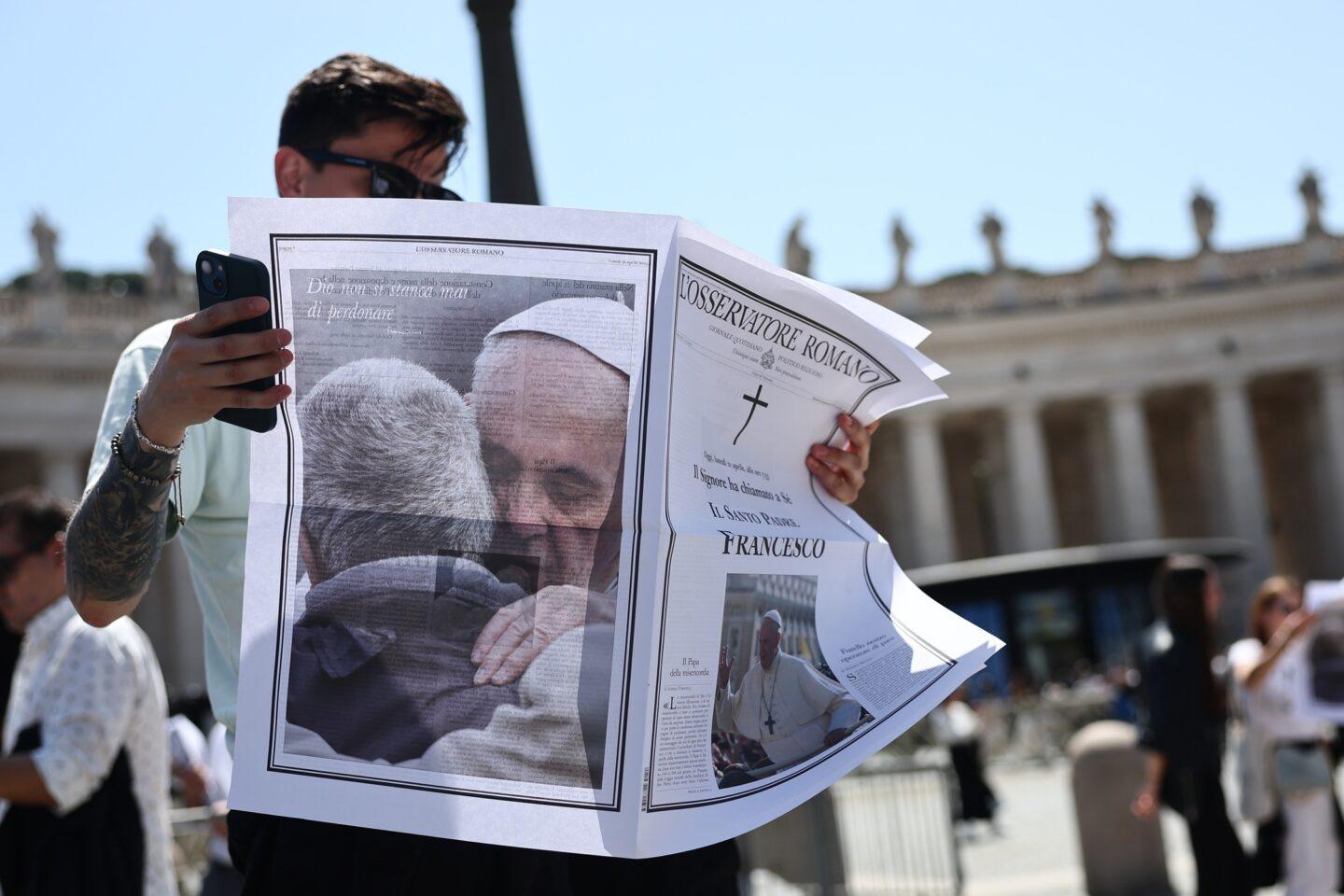 Osoba przegląda wydanie „L’Osservatore Romano” dzień po śmierci papieża Franciszka, na placu Świętego Piotra w Watykanie, 22 kwietnia 2025 r.