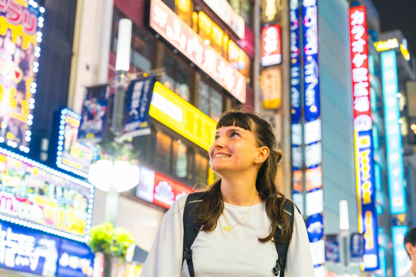 Na zdjęciu europejska turystka podziwiająca życie nocne Tokio.