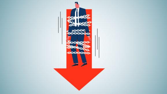 Na grafice biznesmen ciągnięty w dół na czerwonej strzałce