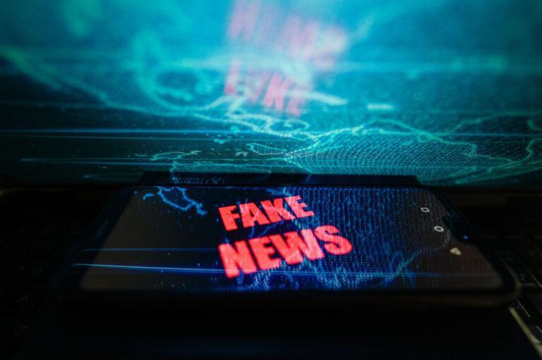 Na ilustracji napis Fake News na tle informacyjnego szumu