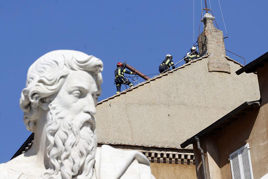 Na zdjęciu strażacy montują na dachu Kaplicy Sykstyńskiej komin, z którego dym będzie sygnalizował wybór papieża