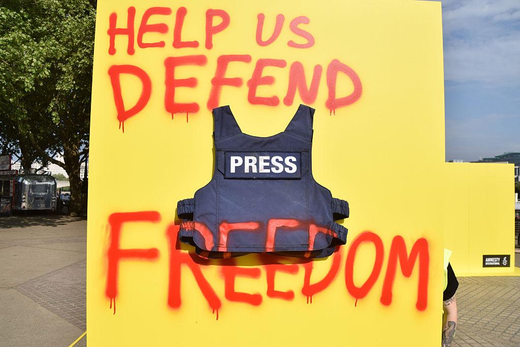 Na zdjęciu kamizelka kuloodporna z napisem PRESS oraz napis Help us defend freedom