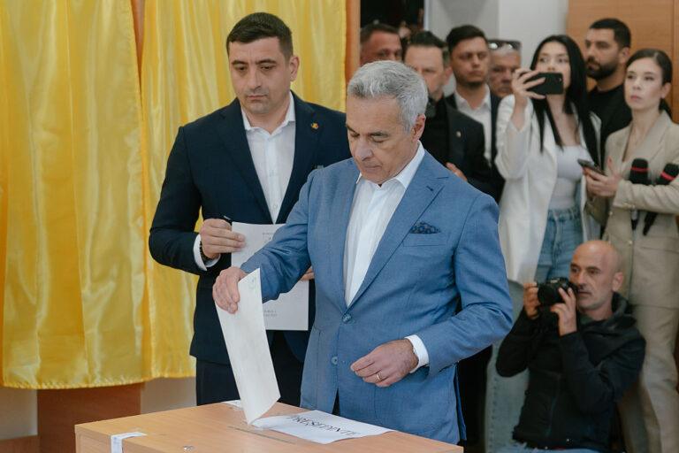 George Simion, kandydat na prezydenta i lider Sojuszu na rzecz Unii Rumunów (AUR) przygotowuje się do oddania głosu obok byłego kandydata na prezydenta Calina Georgescu.