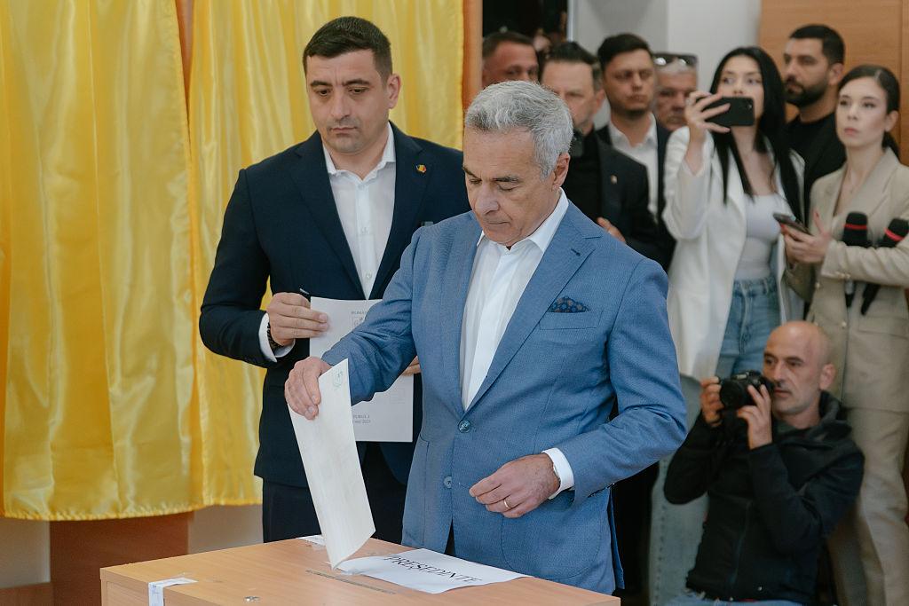 George Simion, kandydat na prezydenta i lider Sojuszu na rzecz Unii Rumunów (AUR) przygotowuje się do oddania głosu obok byłego kandydata na prezydenta Calina Georgescu.