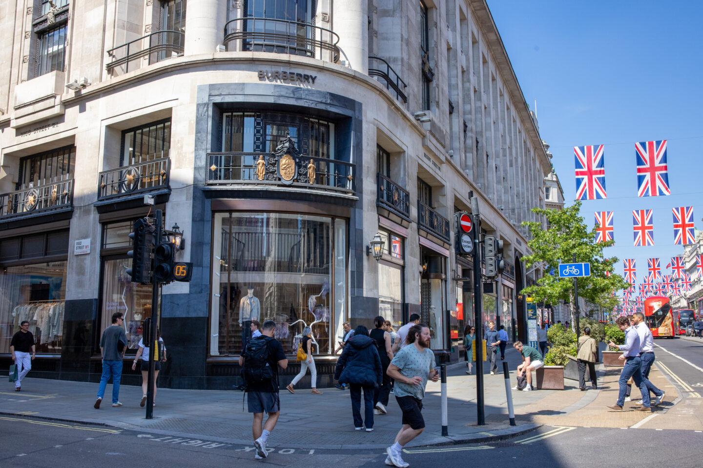 Zdjęcie przedstawia sklep luksusowej marki Burberry w Wielkiej Brytanii w Londynie przy Regent Street i osoby robiące zakupy na ulicy przed sklepem