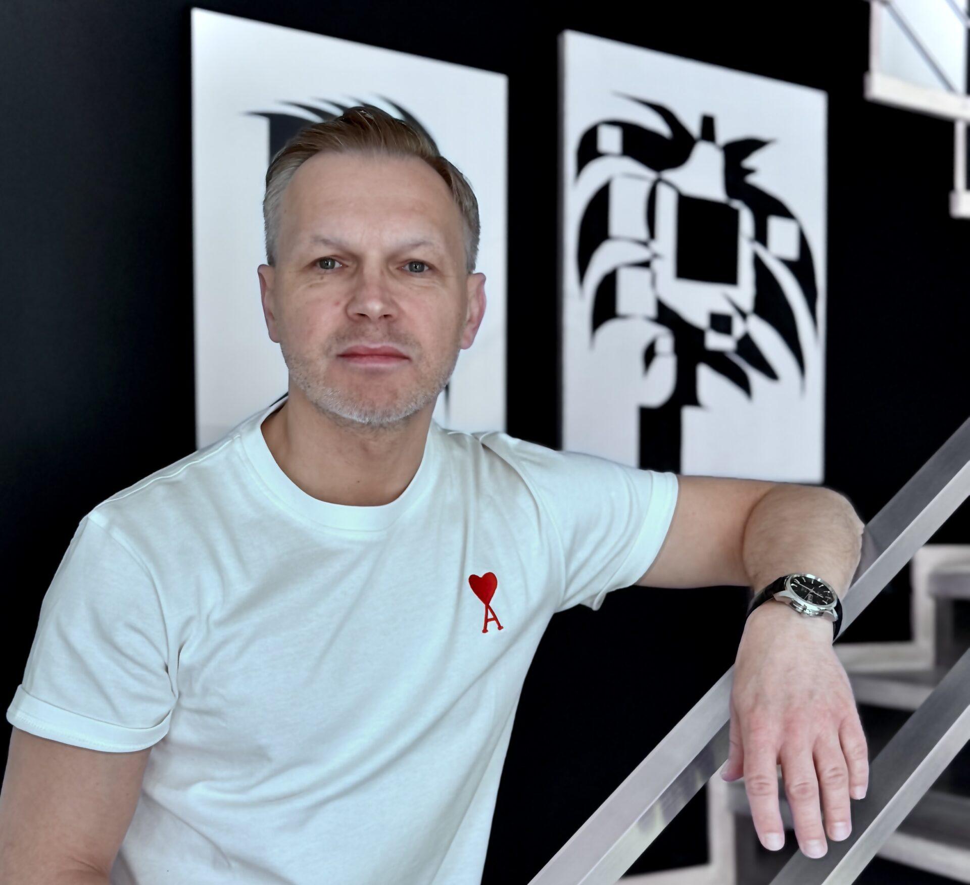 Bartosz Berestecki, prezes spółki PayTel. W tle prace Cezarego Poniatowskiego (bez tytułu)