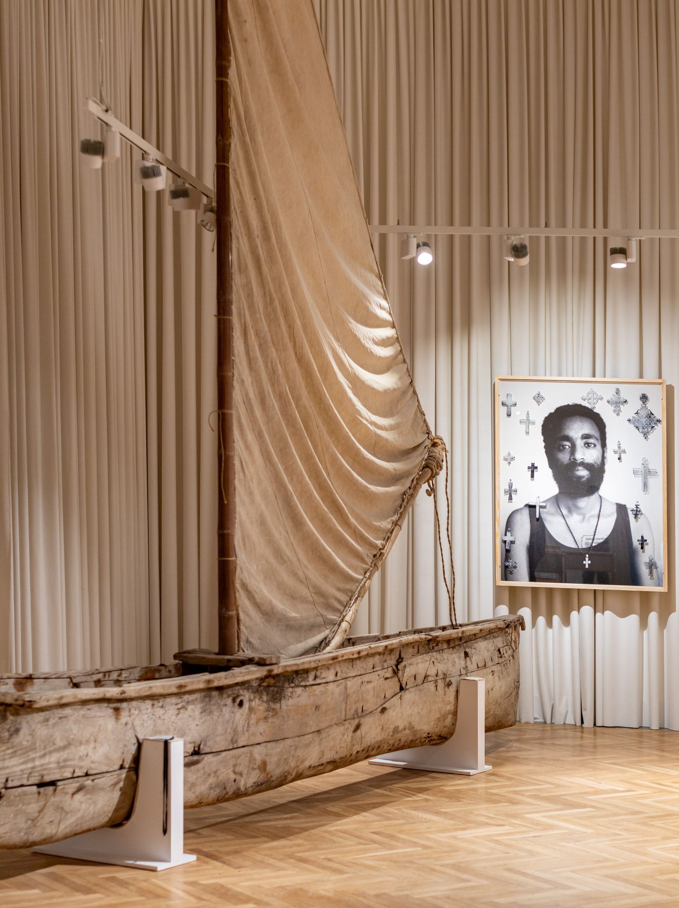 Łódź zakupiona przez Wacława Korabiewicza na wschodnim brzegu Afryki zestawiona ze zdjeciem „Mężczyzna z krzyżem” Witka Orskiego, wystawa „Wybielanie”