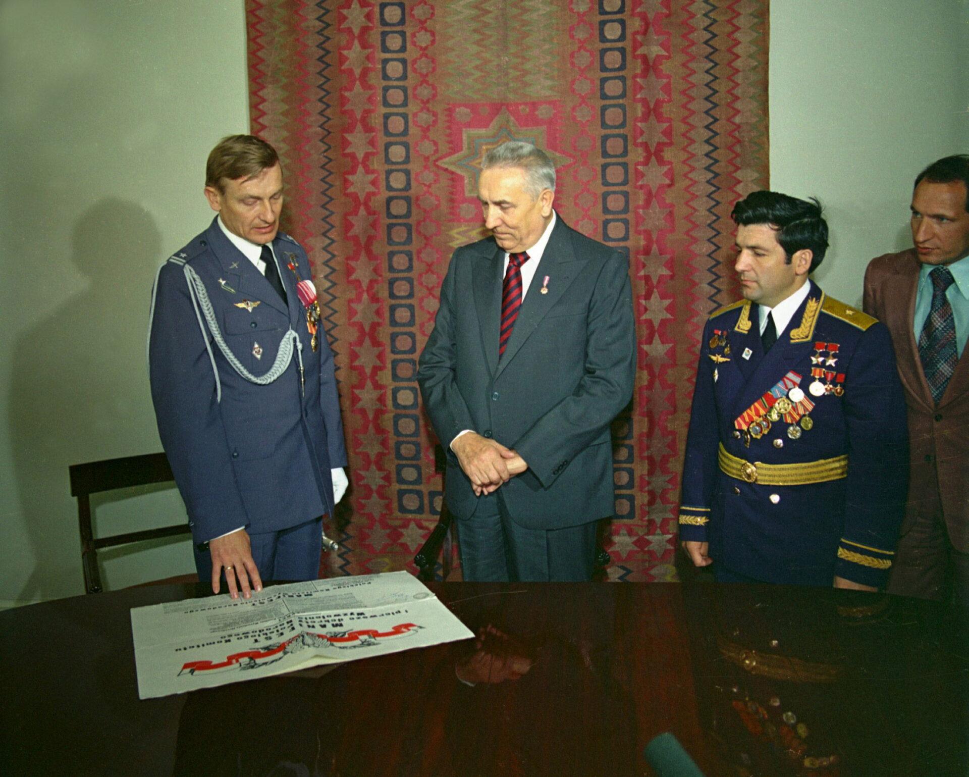 Mirosław Hermaszewski (z lewej) i Piotr Klimuk (z prawej) wręczają I sekretarzowi PZPR Edwardowi Gierkowi egzemplarz Manifestu Lipcowego, który mieli ze sobą na statku Sojuz 30. (fot. Leszek Łożyński)