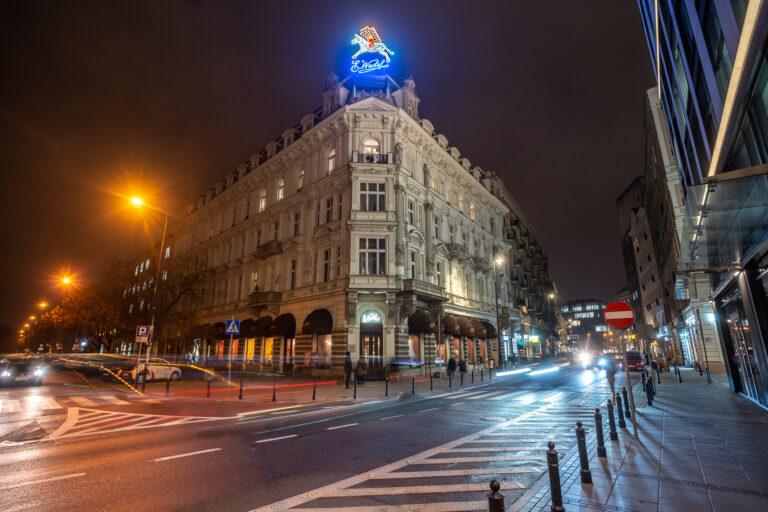 Zdjęcie przedstawia neon Wedla nad budynkiem, w którym mieści się pijalnia czekolady firmy, na ul. Szpitalnej w Warszawie