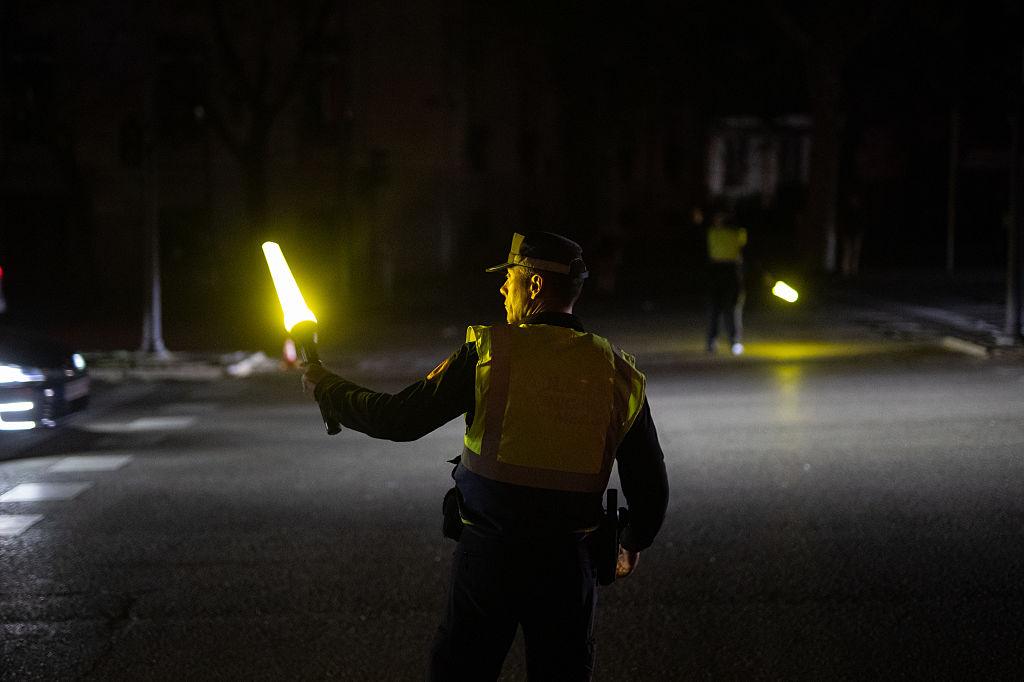 Funkcjonariusz Straży Miejskiej kieruje ruchem w Madrycie w czasie ogólnokrajowej awarii systemu energetycznego.