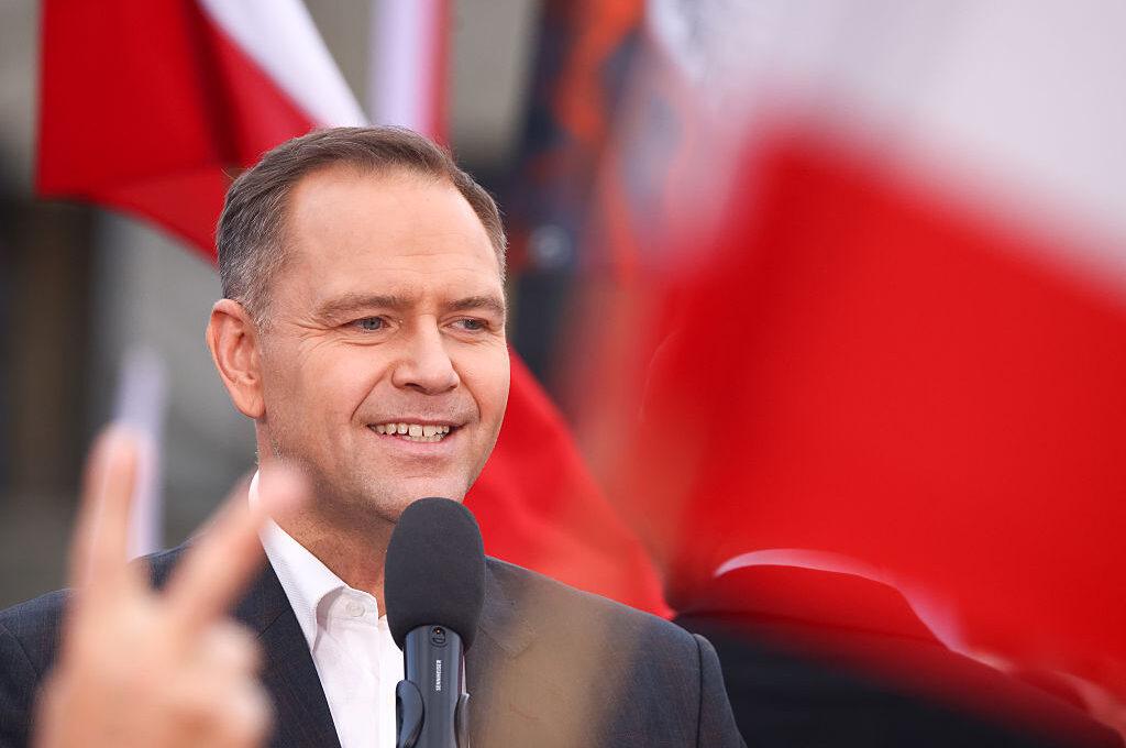 Na zdjęciu Karol Nawrocki otoczony czerwono-białymi flagami