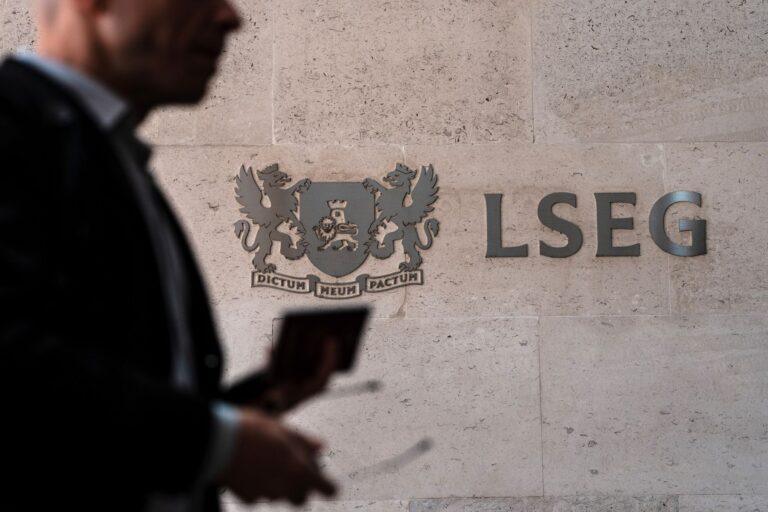 Zdjęcie przedstawia profil osoby w garniturze przed logo London Stock Exchange Group