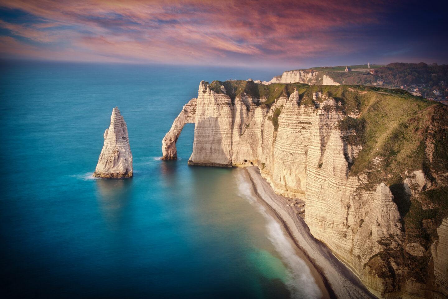 Zdjęcie plaży w Étretat we Francji o zachodzie słońca.