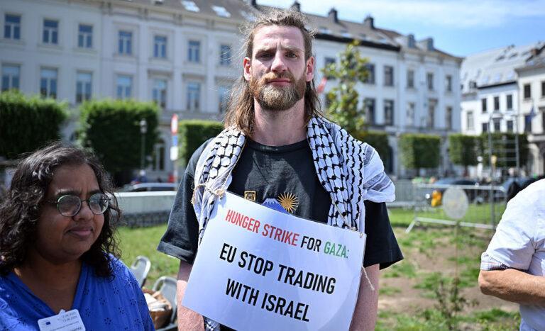 Na zdjęciu pracownik instytucji UE z transparentem poparcia dla Gazy