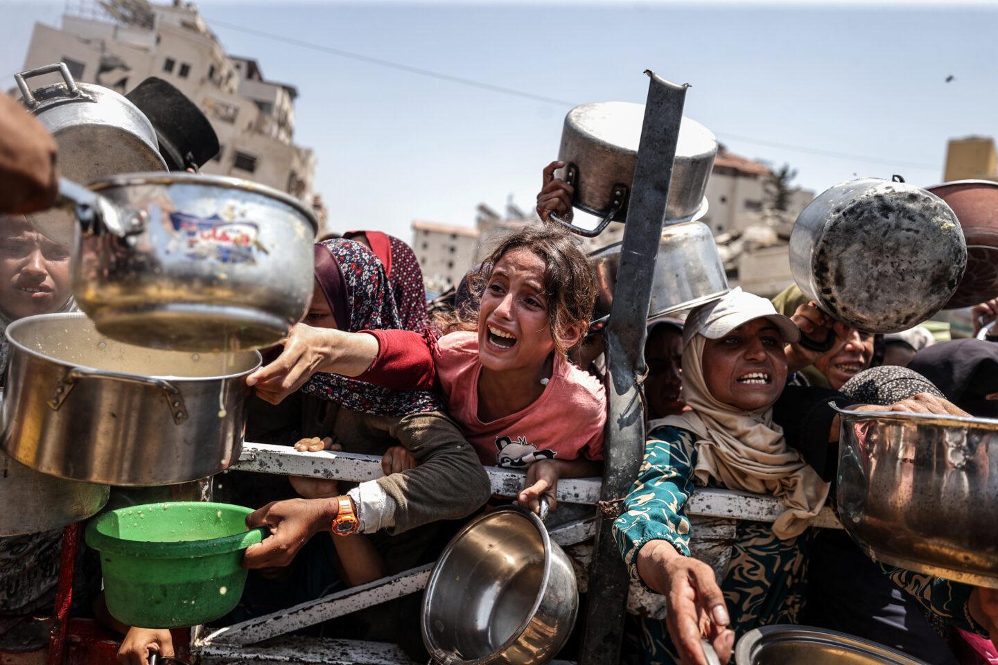 Na zdjęciu ludzie walczą o jedzenie w Gazie