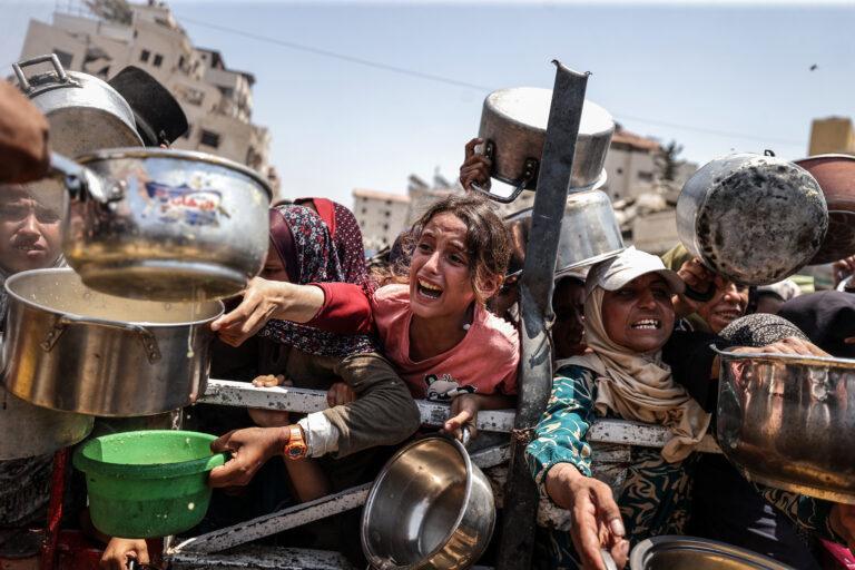 Na zdjęciu ludzie walczą o jedzenie w Gazie