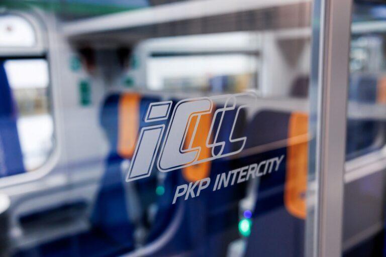 Zdjęcie przedstawia logo PKP Intercity na oknie przedziału w pociągu