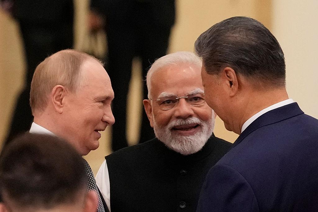 Xi Jinping, Narendra Modi i Władimir Putin uśmiechają się stojąc naprzeciwko siebie w kuluarach szczytu SzOW