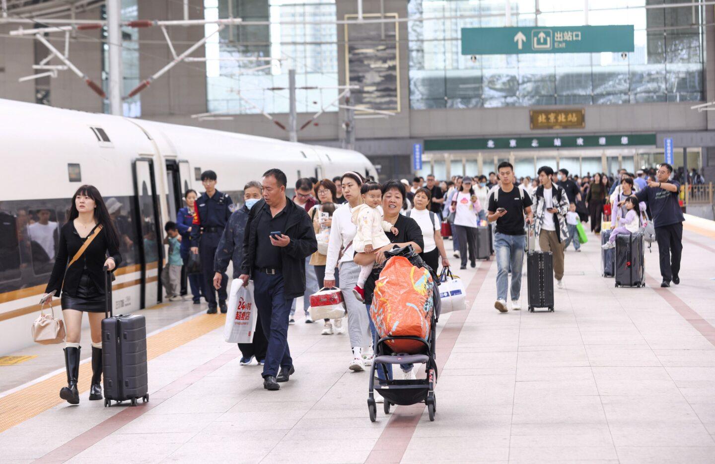 Pasażerowie z bagażami na tle pociągu