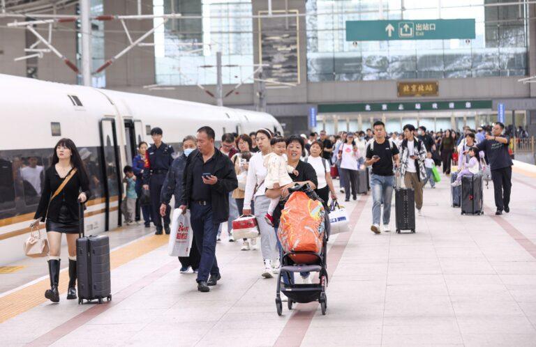 Pasażerowie z bagażami na tle pociągu