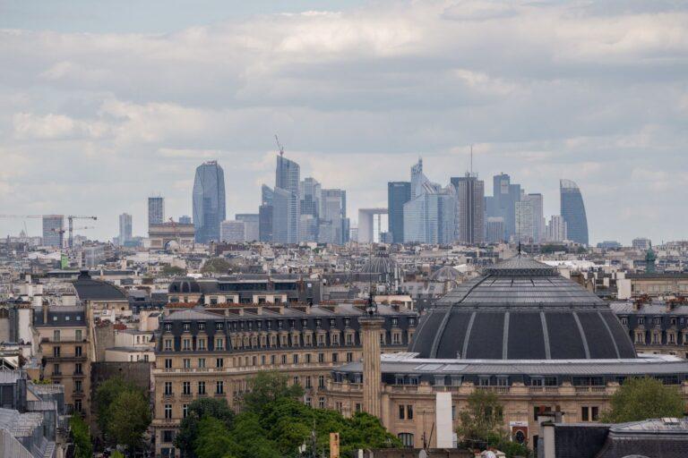 Zdjęcie przedstawia panoramę Paryża z biurowcami w tle