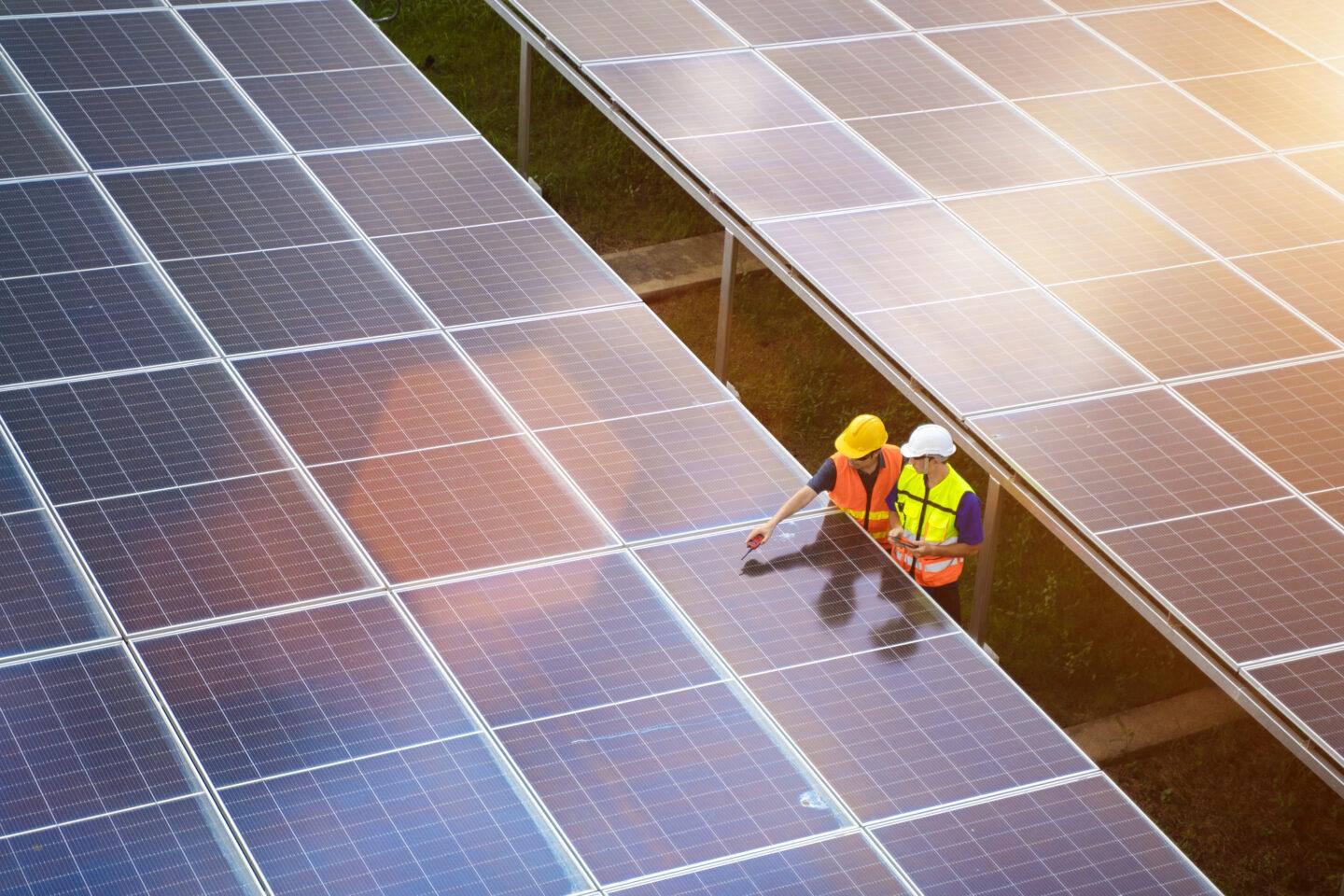 Inżynierowie kontrolują farmę fotowoltaiczną.