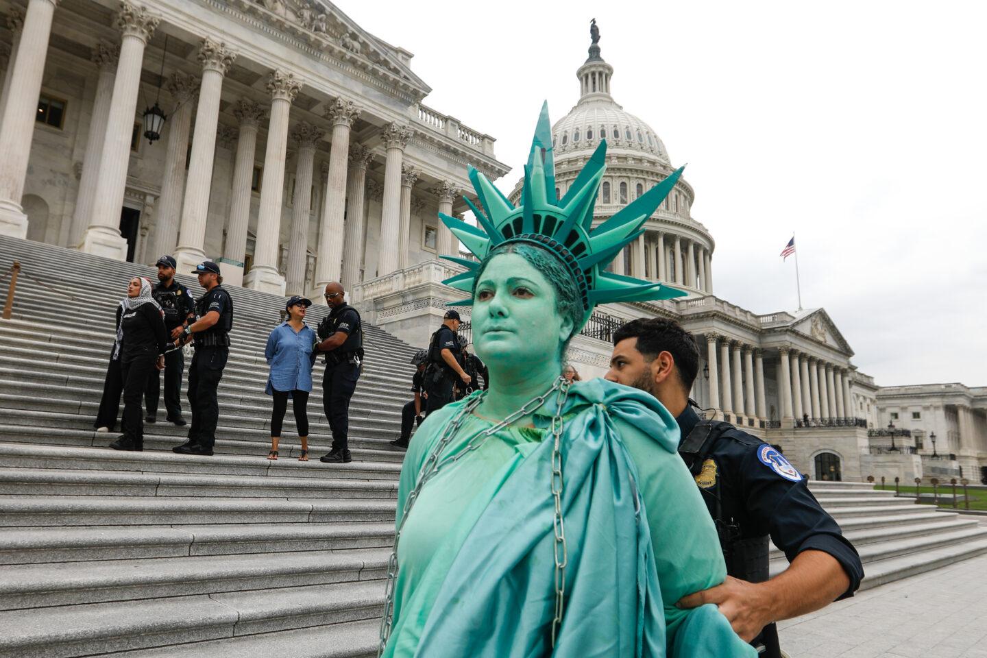 Na zdjęciu zatrzymanie przebranej za Statuę Wolności uczestniczki protestu przed amerykańskim Kapitolem