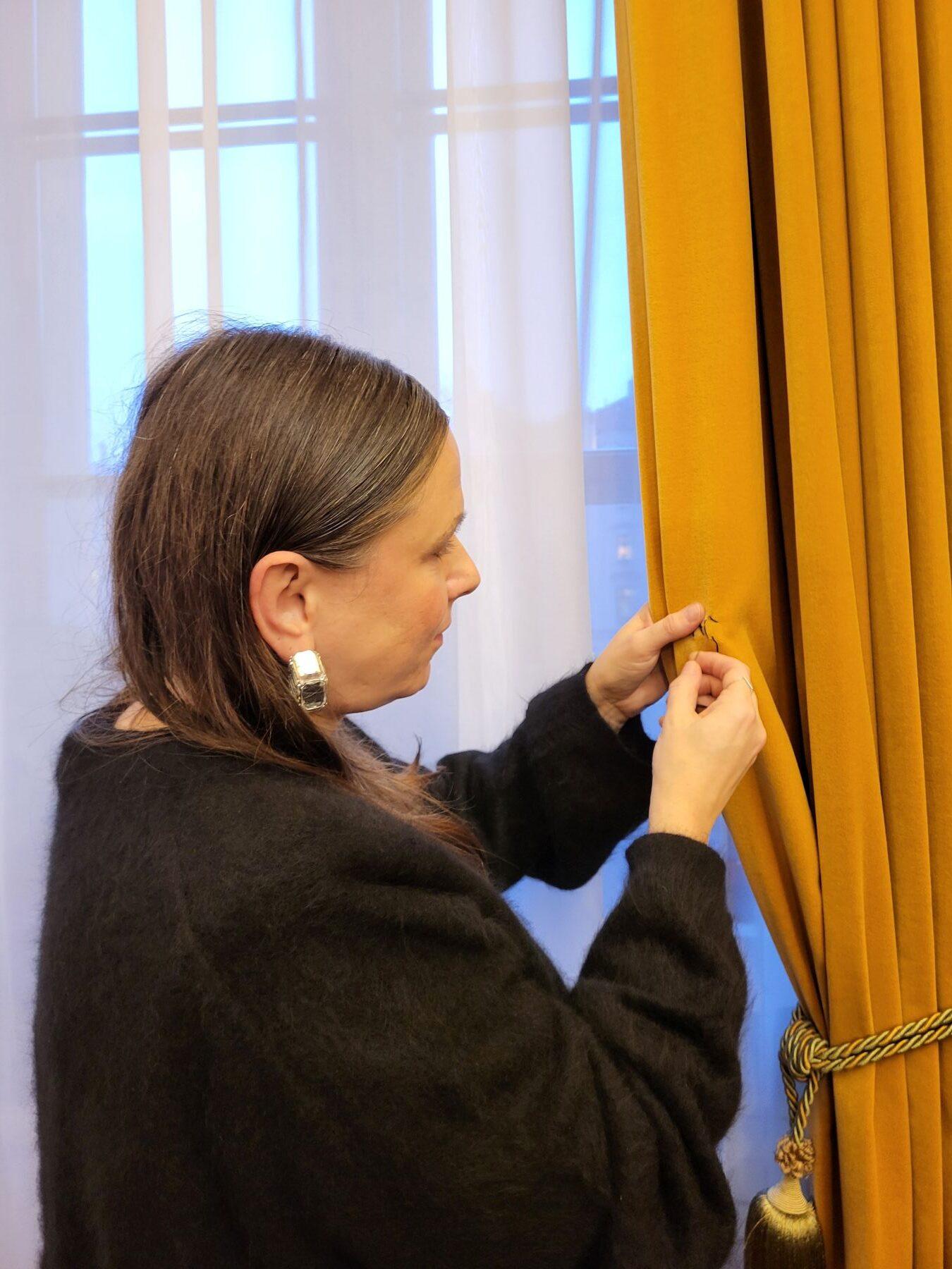 Monika Drożyńska haftuje na zasłonie w gabinecie prezydenta miasta.