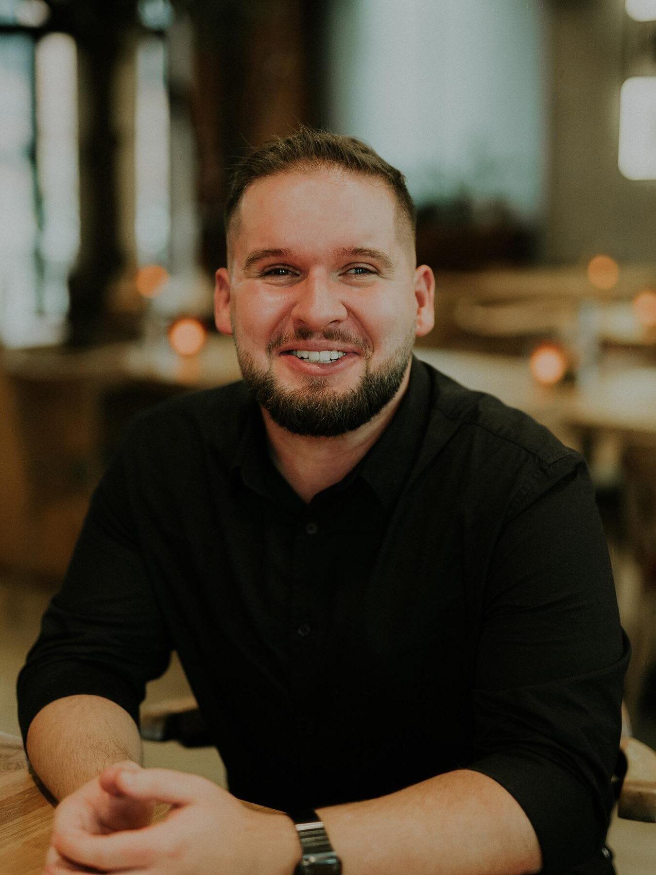 Adrian Now, twórca internetowy prowadzący kanały W Ciemno, na swoich kanałach społecznościowych testuje i pokazuje sprzęt elektroniczny, gadżety oraz oprogramowanie. Trudności ze wzrokiem, z którymi mierzy się od urodzenia, skierowały jego zainteresowania w stronę technologii dostępnych dla osób niewidomych i słabowidzących. Fot. Archiwum prywatne Adrian Now