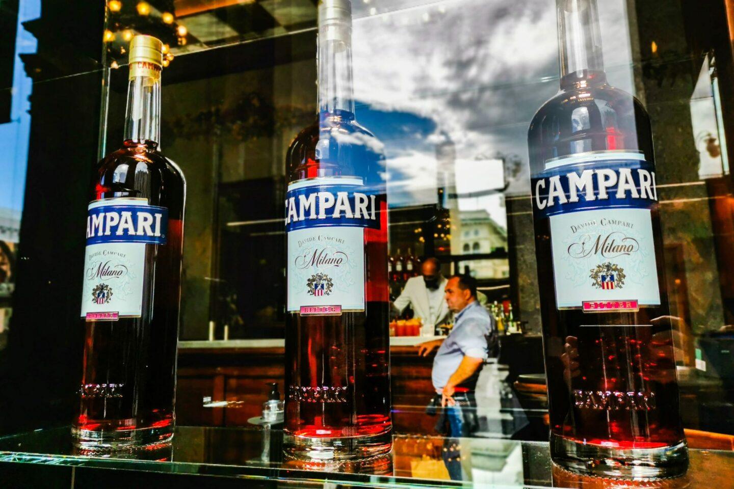 Zdjęcie przedstawia butelki Campari w barze w Mediolanie