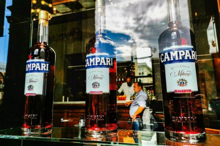 Zdjęcie przedstawia butelki Campari w barze w Mediolanie