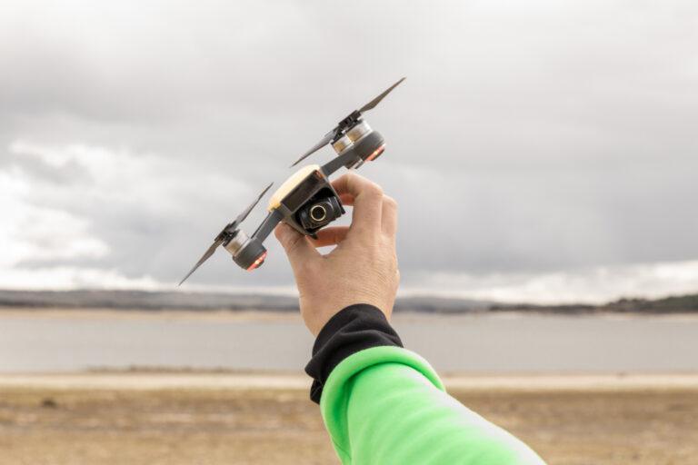 Na zdjęciu ręka trzymająca niewielkiego drona