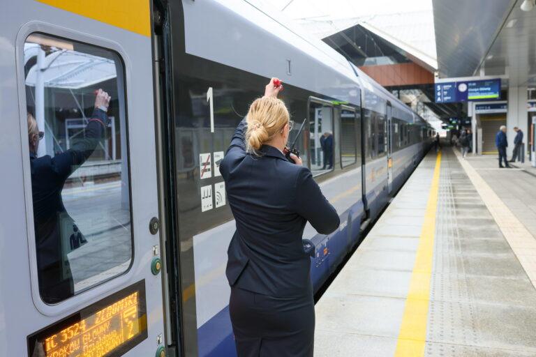 konduktor z gwizdkiem na peronie przy pociągu