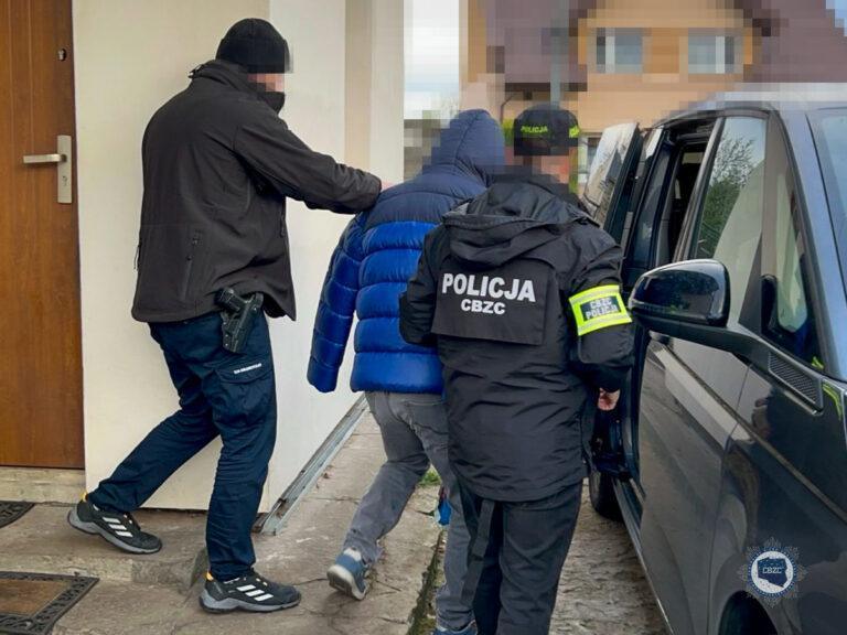 Policjancji z Centralnego Biura Zwalczania Cyberprzestępczości wyprowadzają z budynku zatrzymanego w trakcie akcji "Game Over".