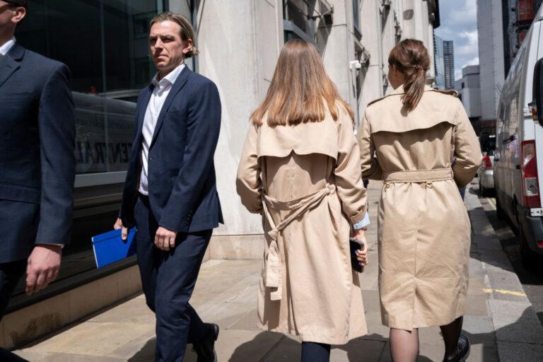 Na zdjęciu kobiety i mężczyźni na ulicy w strojach biznesowych